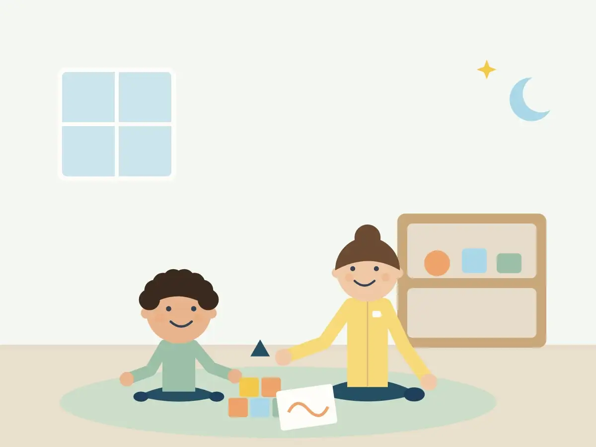 Criança e terapeuta brincam no chão com blocos e desenho